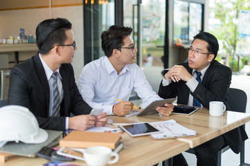 three asian businessman meeting and discussing business in office.