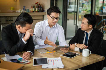 three asian businessman meeting and discussing business in office.