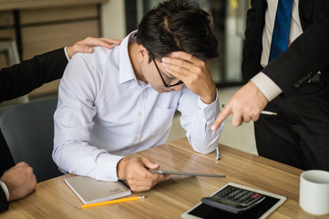 businessman shouted to the employee and point his finger to report, he is very angry for Reported sales decrease. employee is stressed and put hands on his head.