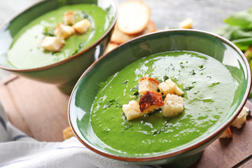 Bowl with delicious spinach soup on table