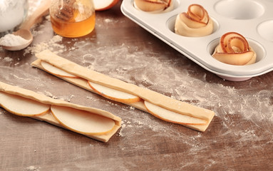 Raw pastry with apple slices on table