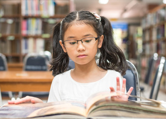 School education and literacy concept with Asian girl kid student learning and reading book in...