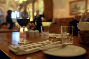 red wine glass serving / romantic dinner in the interior of the restaurant, a table served with a glass of grapes wine