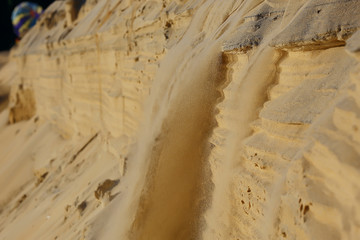 the texture of the sand is drowned by sand dunes / sand avalanche is showered off the dune, an unusual texture of sand