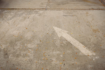 Fototapeta premium White Arrow signs and symbols on concrete road in the parking area.