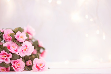 Sweet soft pastel pink korea style flower on white wooden table decoration spakling light wall for valentine or anniversary important day with copy space.