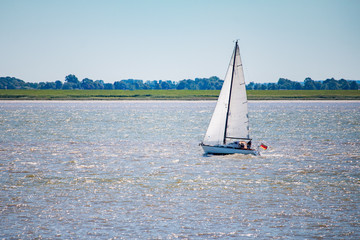 Sailboat or yacht on a lake in nice weather and blue sky