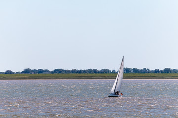 Sailboat or yacht on a lake in nice weather and blue sky