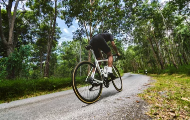 Wandaufkleber Cyclist He was cycling uphill climb in the woods. © torwaiphoto