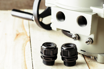 Small electric drive (actuator) gray colour for valves. . Wooden and fabric background.