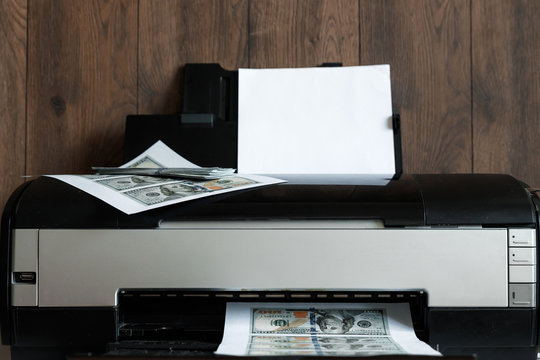 Printer and printed US dollars, counterfeit banknotes, currency counterfeiting. Counterfeiters, printing press, inflation.