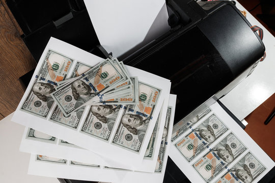Printer and printed US dollars, counterfeit banknotes, currency counterfeiting. Counterfeiters, printing press, inflation.