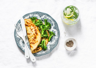 Omelet with broccoli and tarragon lemon lemonade on a light background, top view. Healthy breakfast or snack. Flat lay