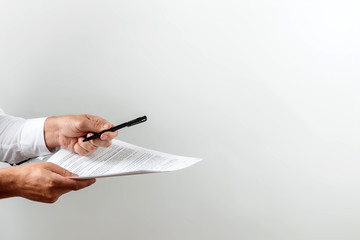 Male hands of a businessman suggest signing a contract. Light background