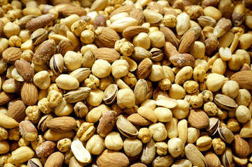 Background mixture of different nuts. Pistachios, almonds, hazelnuts close-up.
