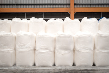 Big white jumbo bag of sugar stacking in warehouse ready for export.