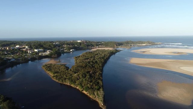 Flat wide shallow delta of Nambucca river flowing along Nambucca heads town where enterign Pacific ocean through sand dunes.
