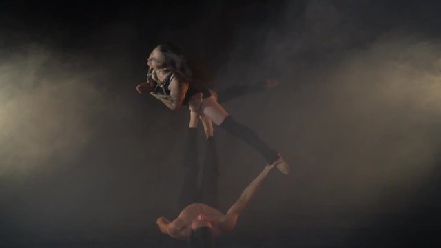 Shibari on acro yoga, bound woman on the legs of a man