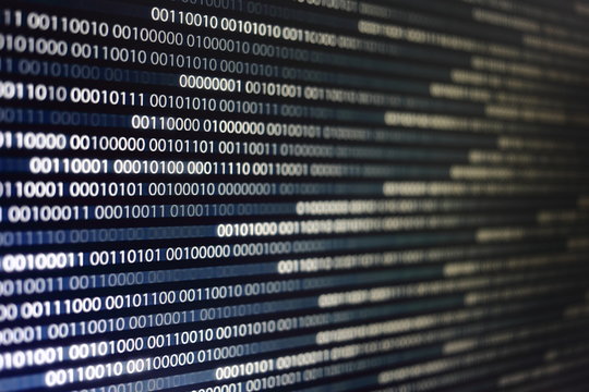 blocks of binary data. Blockchain concept. blue background with computer digital binary code bit number one and zero text. selective focus on the far end of the computer display out of focus in front.