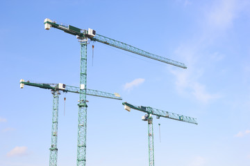 Three industrial construction tower cranes.