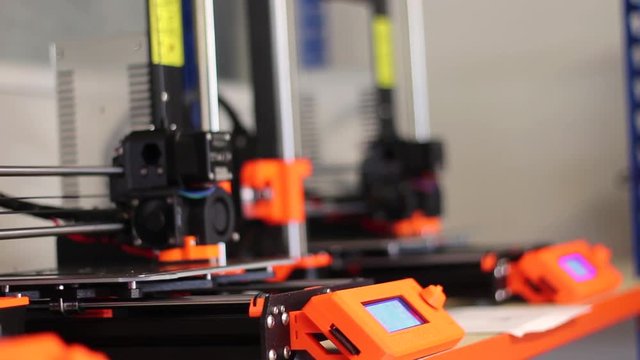 Close up of three brand new Prusa MK 3 3D printers, printing.