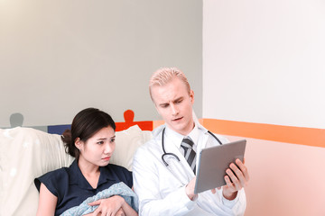 Young male doctor provides treatment counseling to patients in hospital.