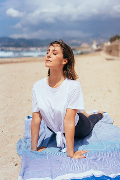 Young woman stretching on beach
