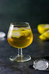 Glass of brandy and ice, lemons in the background