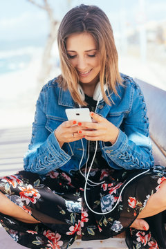 Young woman browsing for music on her mobile