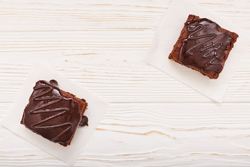 homemade chocolate brownies on white wooden background, top view