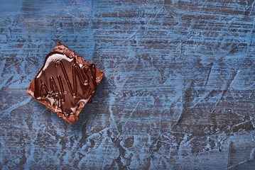 homemade chocolate brownies on dark blue background, top view
