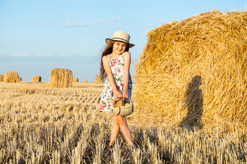 Happy girl on field of wheat with bread