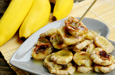 Grilled Bananas With Coconut- Caramel Sauce with fresh bananas on bamboo mat.
 Banana Thai Dessert menu.
