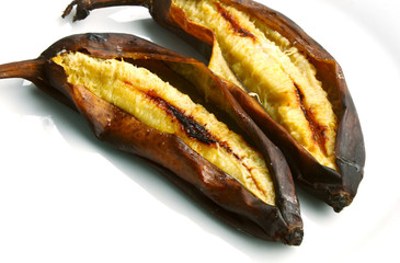 Cavendish Bananas grilled on white dish with wooden background.