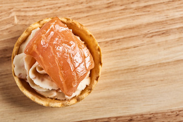 tartlets with mascarpone and red fish on a wooden table. copyspace.