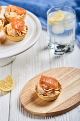 tartlets with mascarpone and red fish on a wooden table