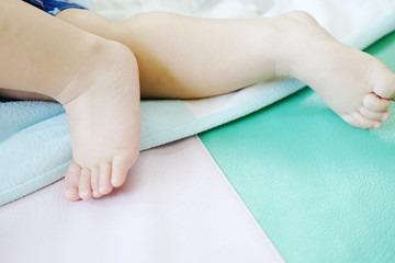 Closeup new born little baby feet.Baby on white bed 
