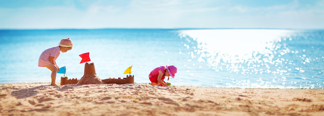 Boy and girl playing on the beach - obrazy, fototapety, plakaty