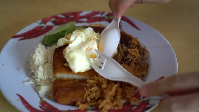 Hand mixing and eating nasi lemak Singapore, Malaysian famous food