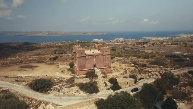 Close Aerial shot rotating around St Agatha's Red Tower in Mellieha Malta