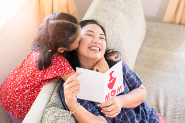 Daughter give mother day greeting card to mom