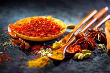 Saffron. Various Indian Spices on black stone table. Spice and herbs on slate background. Cooking ingredients