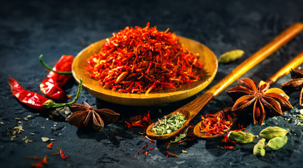 Saffraan. Diverse Indiase kruiden op zwarte stenen tafel. Spice en kruiden op leisteen achtergrond. Ingrediënten koken