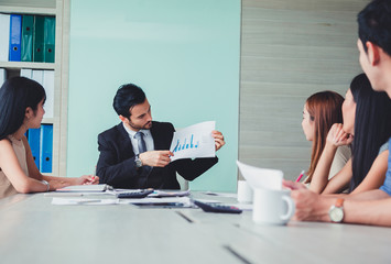 Manager holding papers hands and Smiling Professional team of coworlcers making great business discussion in modern office teamwork people..