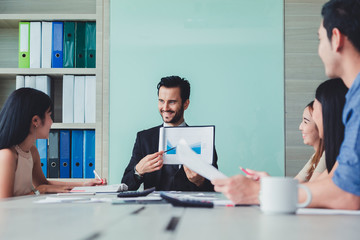 Manager holding papers hands and Smiling Professional team of coworlcers making great business discussion in modern office teamwork people.