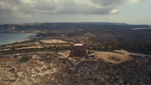 High Aerial shot rotating around St Agatha's Red Tower in Mellieha Malta