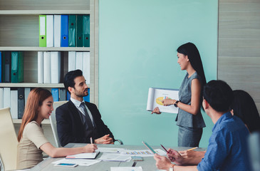 Woman of business discussing ducuments and ideas at meeting.
