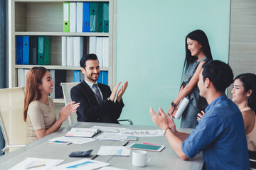 Woman of business discussing ducuments and ideas at meeting.