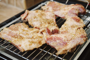 Delicious pieces of meat with spices on the electric grill.