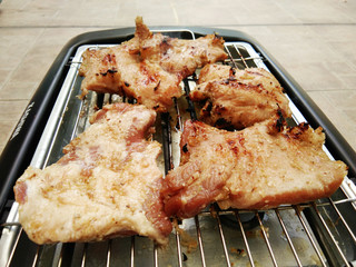 Delicious pieces of meat with spices on the electric grill.